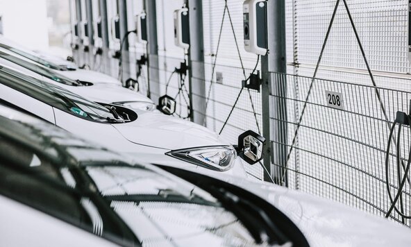 Mehrere weiße Firmenfahrzeuge sind an Wallbox angeschlossen